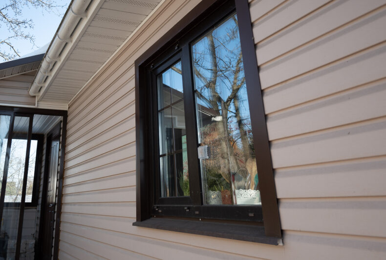 A black-framed window, weather-resistant vinyl siding, perfect for extreme climates.