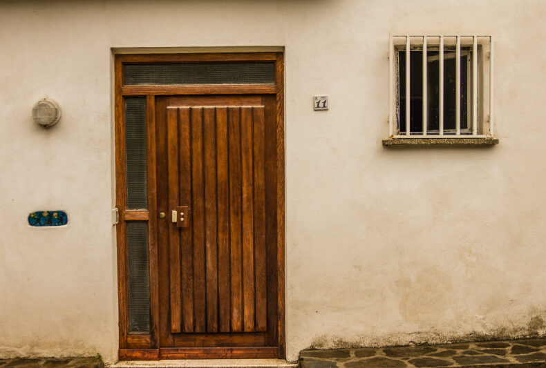 A classic wooden door, offering elegance but requiring regular maintenance to prevent warping.