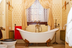 A luxurious bathroom with a freestanding tub, golden accents, and layered lighting design.